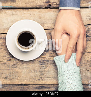 Schließen Sie herauf Bild des Menschen Beziehungen Hintergrund. Man Betrieb Frauenhand in der Nähe von Kaffee. Warme Farbe getönt Bild Stockfoto
