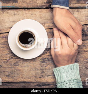 Schließen Sie herauf Bild des Menschen Beziehungen Hintergrund. Man Betrieb Frauenhand in der Nähe von Kaffee. Warme Farbe getönt Bild Stockfoto