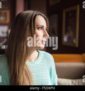 Schöne junge Frau Frühstück in einem Café. Ziemlich kaukasische Mädchen Blick durch Fenster Stockfoto