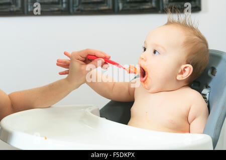 Mutter, die hungrigen sechs Monate altes Baby feste Nahrung Stockfoto