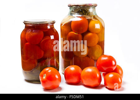 Frisches und eingemachte rote Tomaten in Glas isoliert auf weißem Hintergrund. Tasty Dosentomaten mit Gewürzen und Kräutern in Glas Stockfoto