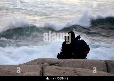 Ein paar oder zwei Menschen auf den Felsen bei Peggys Cove, Nova Scotia, die Nähe zu den Wellen und in der Gefahr des Ertrinkens. Stockfoto