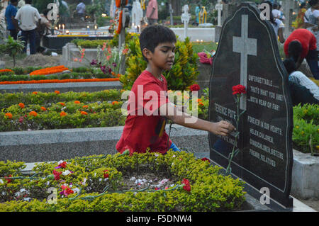 Kolkata, Indien. 2. November 2015. Ein Junge bietet Blume auf das Grab. Katholiken besuchen die Gräber ihrer Angehörigen, wo sie Kerzen, Blumen und streuen Weihwasser während ihrer Feier von "Allerseelen" in Kalkutta. Bildnachweis: Tanmoy Bhaduri/Pacific Press/Alamy Live-Nachrichten Stockfoto