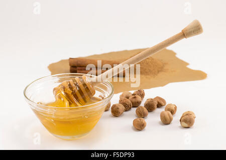 Haselnüsse, Honig und Zimt auf einen weißen Tisch. Gesunder Winter behandelt Stockfoto