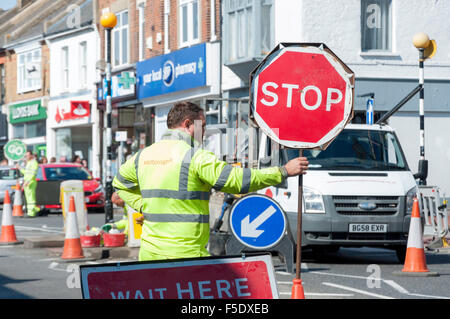 Mann, der Stop-Schild an der Straße hält funktioniert, Broadway, Leigh-on-Sea, Essex, England, Vereinigtes Königreich Stockfoto