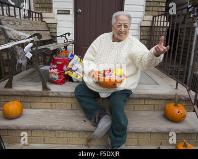Chinesische Frau erwartet Monstern auf ihre Stoop in den Kensington-Abschnitt von Brooklyn, New York, 2015. Stockfoto