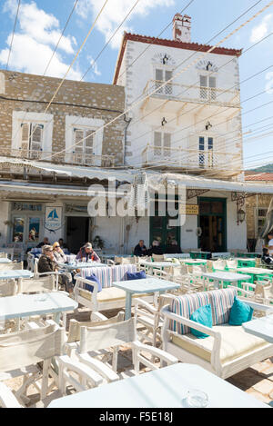 HYDRA, Griechenland - 25. Oktober 2015: Menschen in den Terrassen der Cafés am Kai im Hafen von Hydra Stockfoto