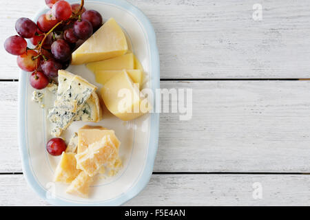 Käse und rote Trauben auf Teller, Planken Essen Hintergrund Stockfoto