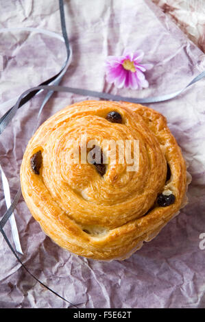 dänische Brötchen mit Rosinen auf violettem Hintergrund Stockfoto