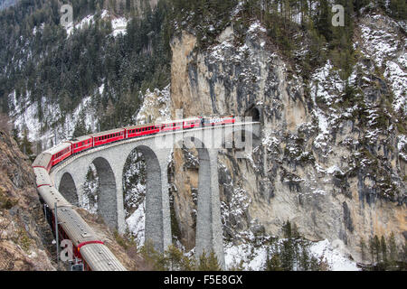 Bernina Express führt über Landwasser-Viadukt, der UNESCO und der verschneiten Wälder, Filisur, Kanton Graubünden (Graubünden), Schweiz Stockfoto