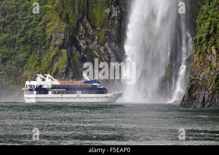 Tourenboot in der Nähe von Stirling Wasserfall, Milford sound, Fiordland National Park, Neuseeland Stockfoto