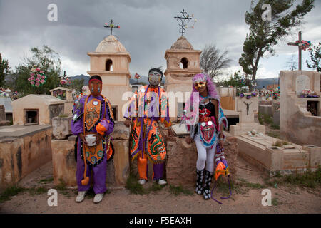 Nachtschwärmer in Kostümen und Masken auf einem Friedhof in Humahuaca während des Karnevals in der Provinz Jujuy in der Anden-Region von Argentinien Stockfoto