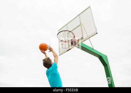 junger Mann im Freien spielen basketball Stockfoto