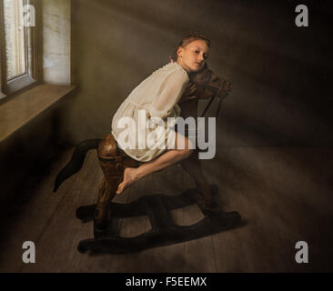 Bildende Kunst Porträt eines Mädchens auf hölzernen Schaukelpferd sitzen Stockfoto