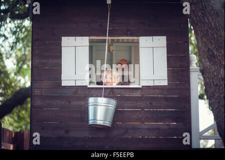 Junge im Baumhaus Blick aus dem Fenster Stockfoto