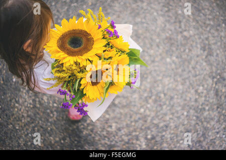 Draufsicht eines Mädchens mit Haufen von Sonnenblumen Stockfoto