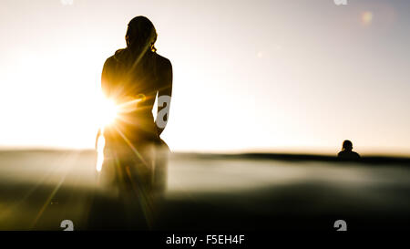 Silhouette der beiden Surfer bei Sonnenaufgang Stockfoto