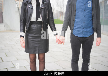 Vorderansicht des kaukasischen Jüngling und Frau posiert in den Straßen der Stadt Hand in Hand-Sorglosigkeit, Freundschaft, Liebe, Jugendkonzept beschnitten Stockfoto
