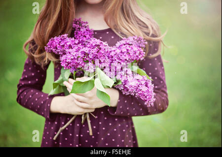 Nahaufnahme eines Mädchens mit lila Blumen Stockfoto