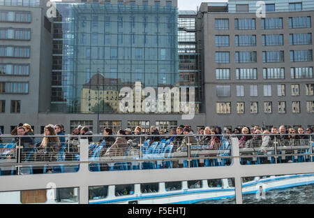Touristen, die auf Bootsfahrt auf der Spree mit Nikolaiviertel Quartal spiegelt sich im Fenster gegenüber, Berlin, Deutschland