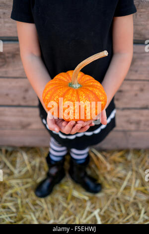 Mädchen hält einen kleinen Kürbis Stockfoto