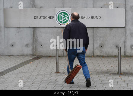 Frankfurt am Main, Deutschland. 3. November 2015. Ein Mann geht mit einem Besen letzten das Logo des "Deutsche Fussball-Bund (DFB)", der Deutsche Fußballbund, auf dem Display im Eingangsbereich, der DFB Zentrale in Frankfurt am Main, 3. November 2015. Steuerbehörden durchsucht das Hauptquartier der deutschen Fußball-Bund DFB in einer Untersuchung mit 2006 World Cup Zahlungen am Dienstag, 3. November. Foto: BORIS ROESSLER/Dpa/Alamy Live News Stockfoto