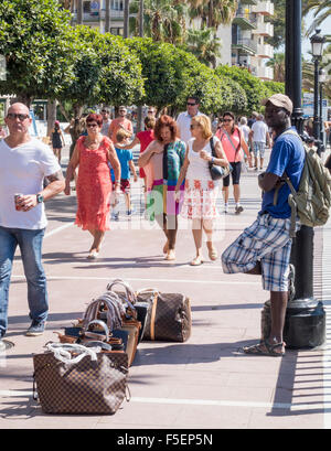 Afrikanischer Mann verkauft gefälschte Handtaschen auf Promenade in Marbella, Spanien Stockfoto