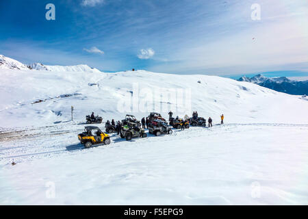 Quads und Quadbikers auf der verschneiten Straße am Col du Granon Stockfoto