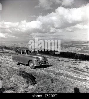 1950er Jahre historische Bild eines Standard Vanguard Autos auf einer Strecke von Landschaft. Es war Standard ersten Post zweiten Weltkrieg Auto. Stockfoto