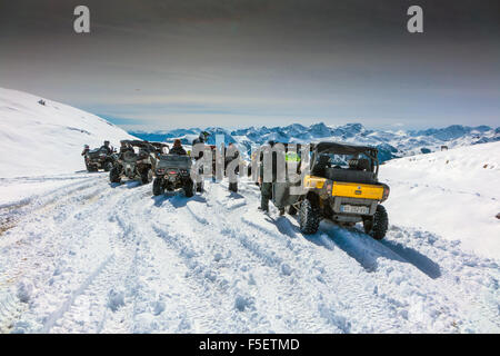 Quads und Quadbikers auf der verschneiten Straße am Col du Granon Stockfoto