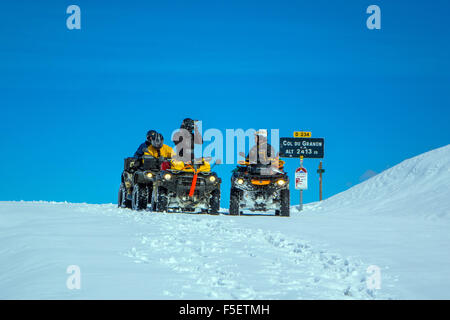 Quads und Quadbikers auf der verschneiten Straße am Col du Granon Stockfoto