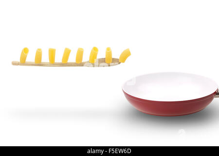 Acht Paccheri, eine typisch italienische Pasta, marschieren auf Holzlöffel in einer keramischen Pfanne. Stockfoto