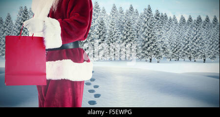 Zusammengesetztes Bild von Santa trägt rote Geschenktüte Stockfoto