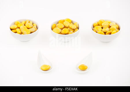 Lupinen Bohnen Snacks Vorspeise in drei kleine Tassen und zwei Keramik Löffel auf weißem Hintergrund. Lupinen sind groß mit Bier. Stockfoto