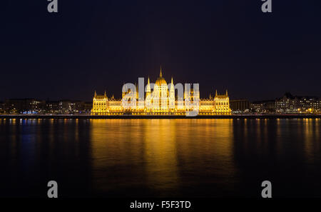 Ein Blick auf das ungarische Parlamentsgebäude an der Donau in der Nacht mit dem Bau beleuchtet und Reflexionen in der wate Stockfoto