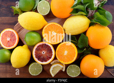 Gemischte Zitrusfrüchte einschließlich Nabel und Blut Orangen, Zitronen und Limetten auf dunklen Holztisch. Stockfoto