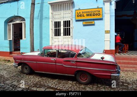 Lokaler Mann saß in der Bodeguita del Medio in Trinidad Kuba auf einen ruhigen Nachmittag mit einem roten und weißen Oldtimer parkten außerhalb Stockfoto