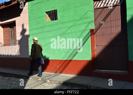 Kubanische Mann zu Fuß in einem Panama-Hut auf einer gepflasterten Straße in Trinidad in den Nachmittag Schatten Stockfoto