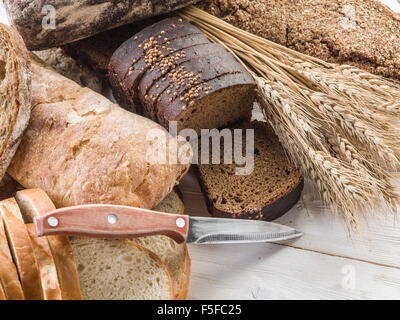 Das Brot und Weizen auf dem Schreibtisch aus Holz. Stockfoto
