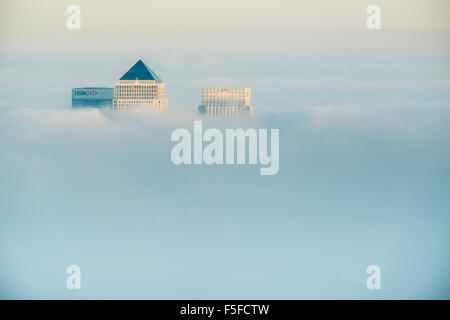 Die Dächer von Hochhäusern der Docklands vor Sonnenuntergang durch die steigenden Nebel und Wolken vor blauem Himmel ragt. Stockfoto