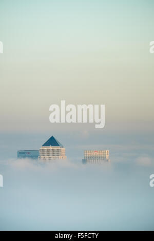 Die Dächer von Hochhäusern der Docklands vor Sonnenuntergang durch die steigenden Nebel und Wolken vor blauem Himmel ragt. Stockfoto