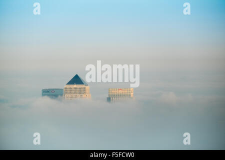 Die Dächer von Hochhäusern der Docklands vor Sonnenuntergang durch die steigenden Nebel und Wolken vor blauem Himmel ragt. Stockfoto