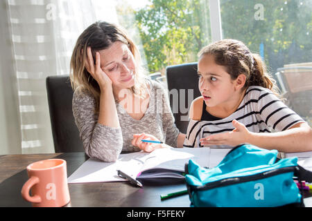 Schulmädchen mit Büchern auf dem Küchentisch zu studieren Stockfoto