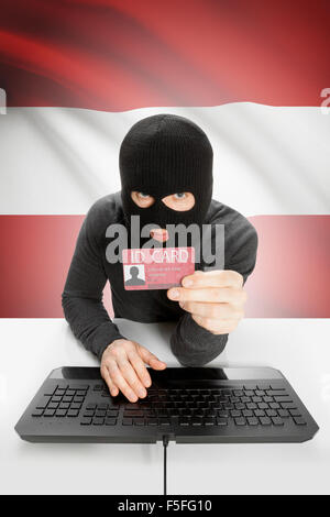 Hacker mit ID-Karte in der Hand und Flagge im Hintergrund - Österreich Stockfoto