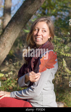 Glückliches Mädchen halten rote Herbst Blatt im Park. Liebe Herbst Stockfoto