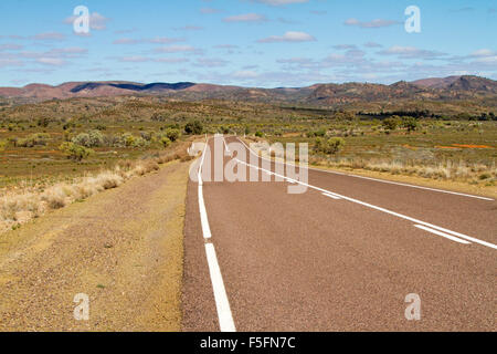 Autobahn durch riesige Outback-Landschaft in Richtung kargen Hügel der Flinders Ranges steigt in blauer Himmel, in Nord-Süd-Australien Stockfoto