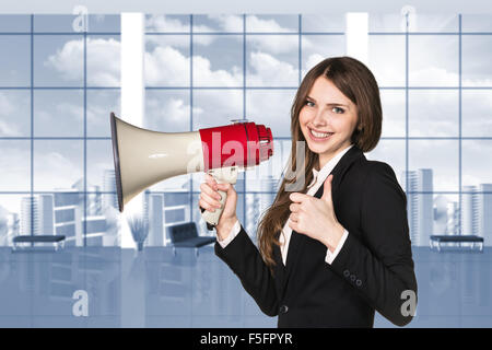 Geschäftsfrau mit Megaphon und Daumen hoch Stockfoto