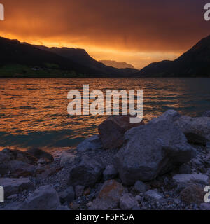 Schöne Aussicht auf den See Resia. Dramatischer Himmel und farbenprächtigen Sonnenuntergang. Alpen, Italien, Europa. Stockfoto