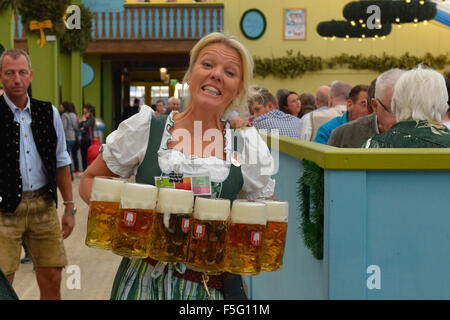 Kellnerin mit Massen von Bier auf dem Oktoberfest in München, Deutschland Stockfoto