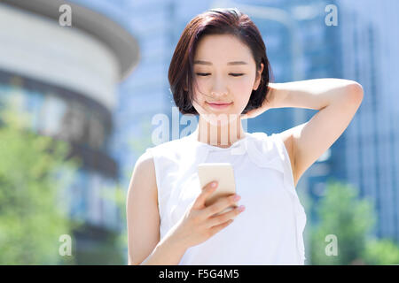 Glückliche junge Frau mit Smartphone Stockfoto